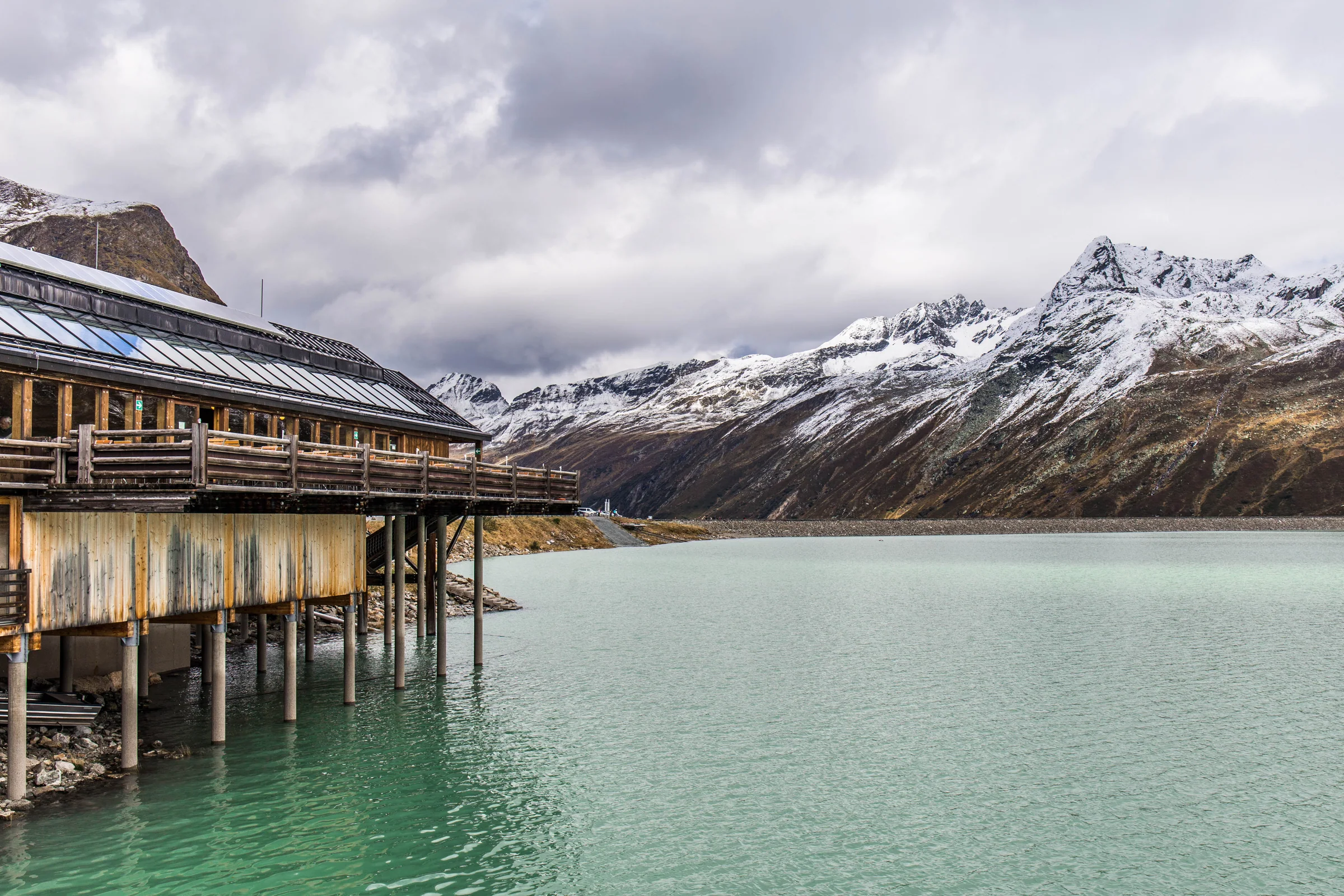 Berggasthaus und Uferweg am türkisfarbenen Silvretta-Stausee auf der Bielerhöhe