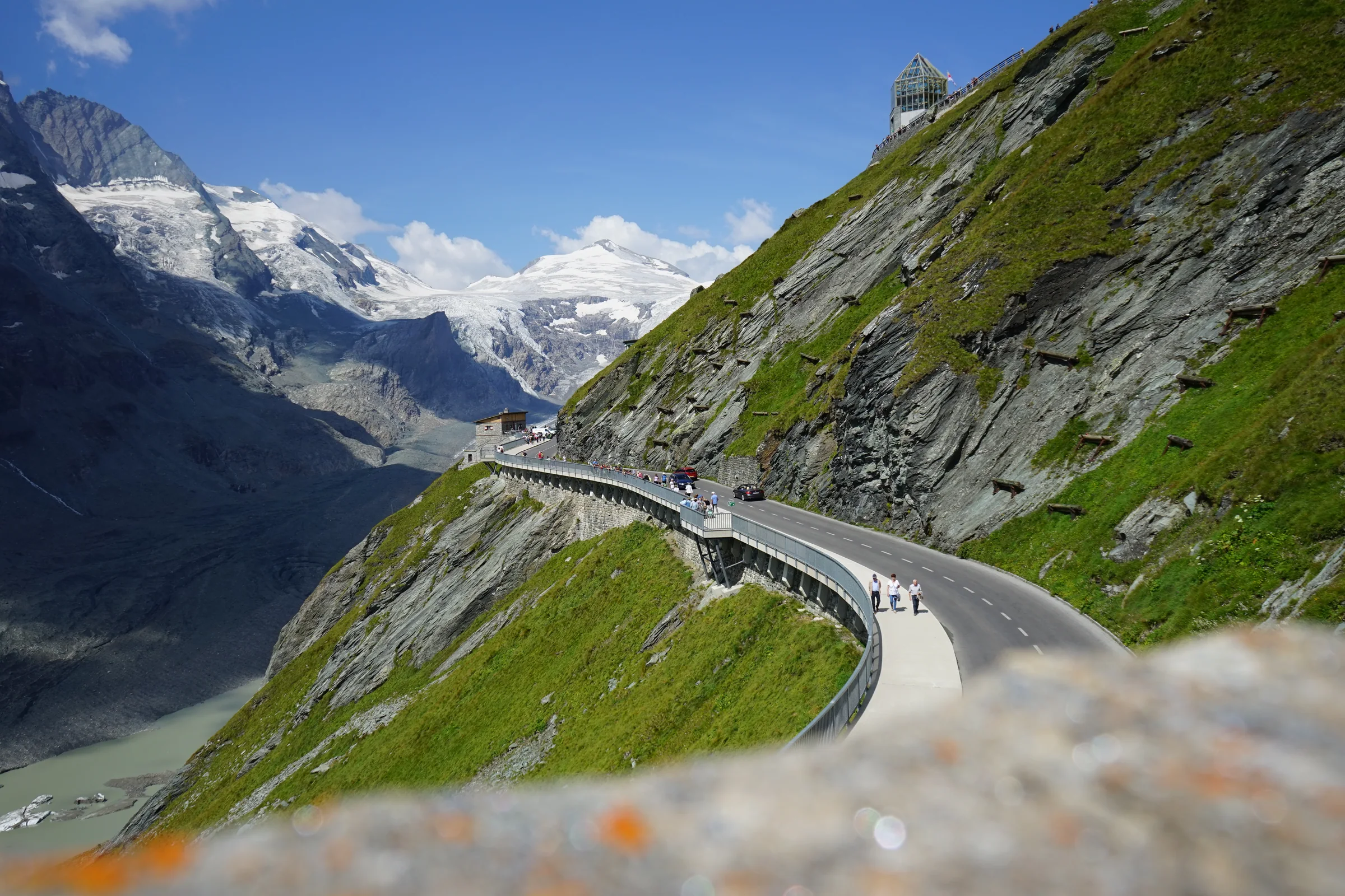 Die Großglockner Hochalpenstraße zieht sich an einer steilen grünen Bergflanke entlang