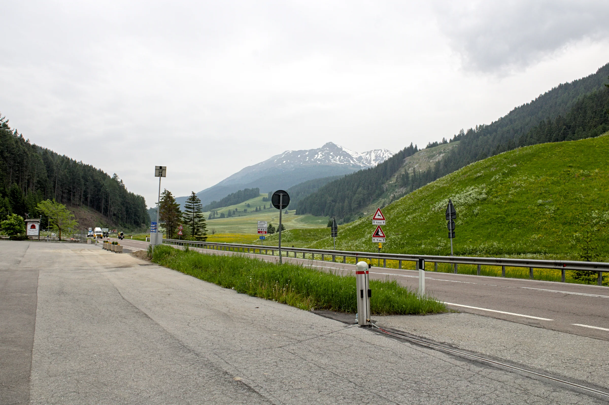 Straße auf dem Reschenpass mit Blick in die alpine Grenzlandschaft