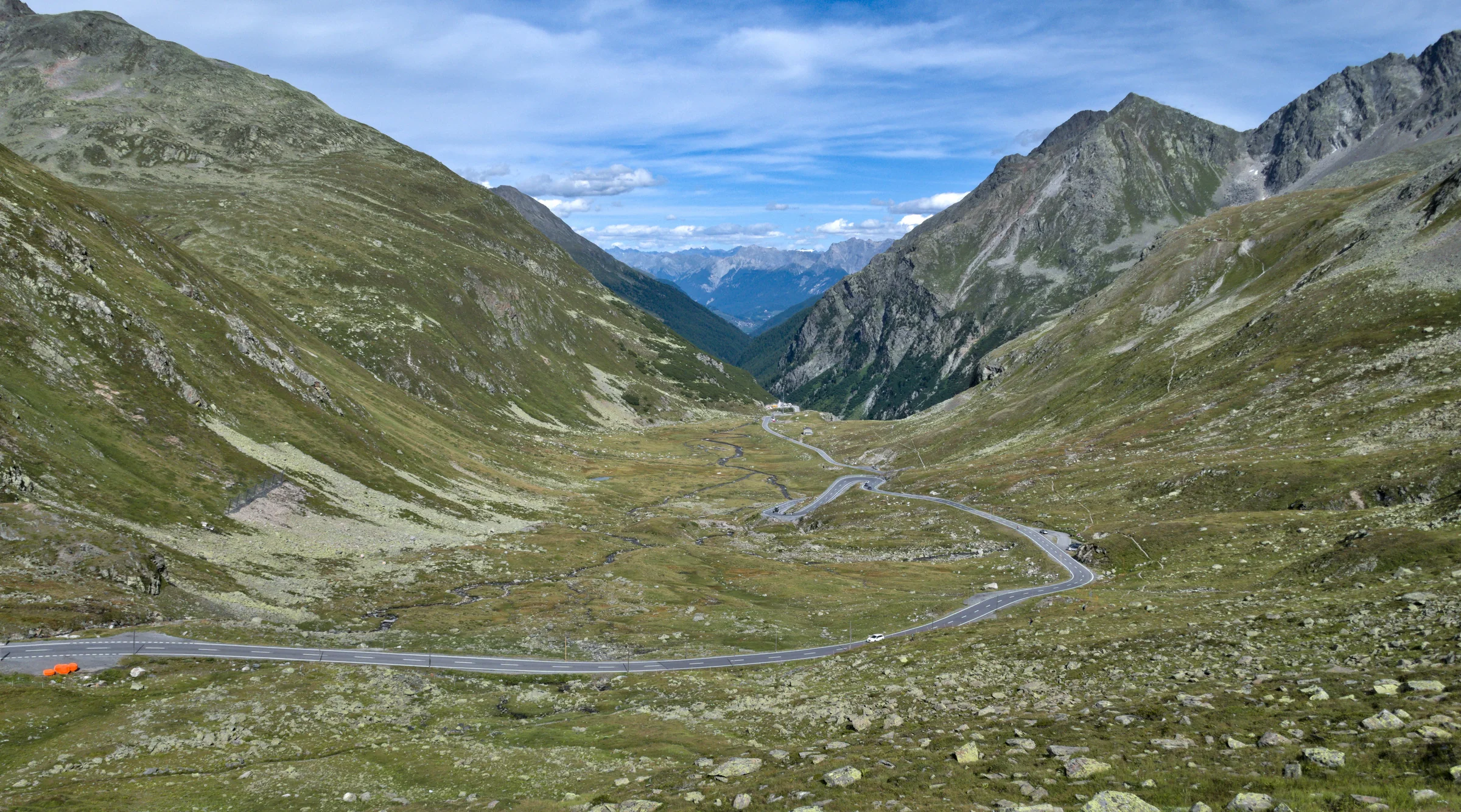Weite Kurven der Flüelapassstraße in der offenen Bündner Hochgebirgslandschaft