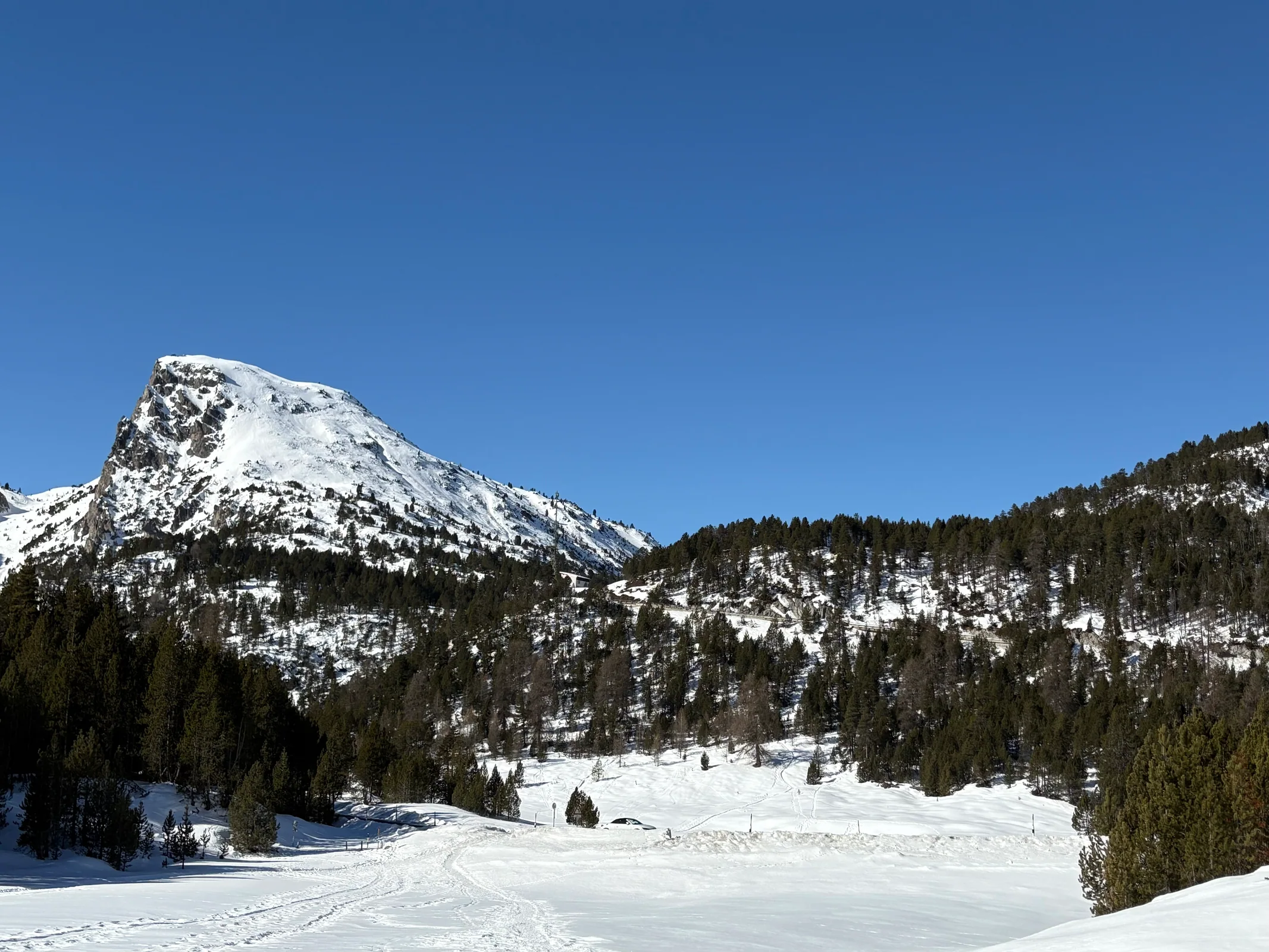 Straße und winterliche Berglandschaft am Ofenpass