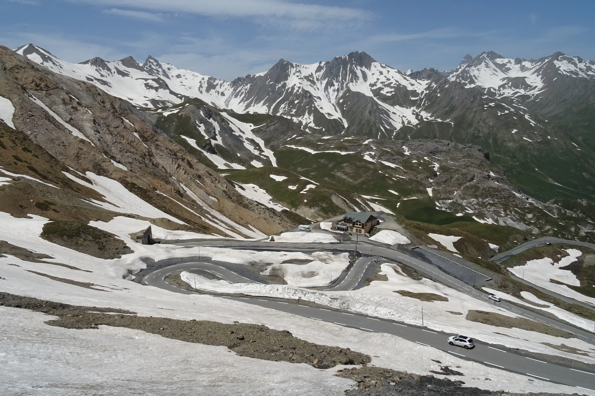 Enge Kehren des Col du Galibier zwischen Schneefeldern und dunklen Alpengipfeln