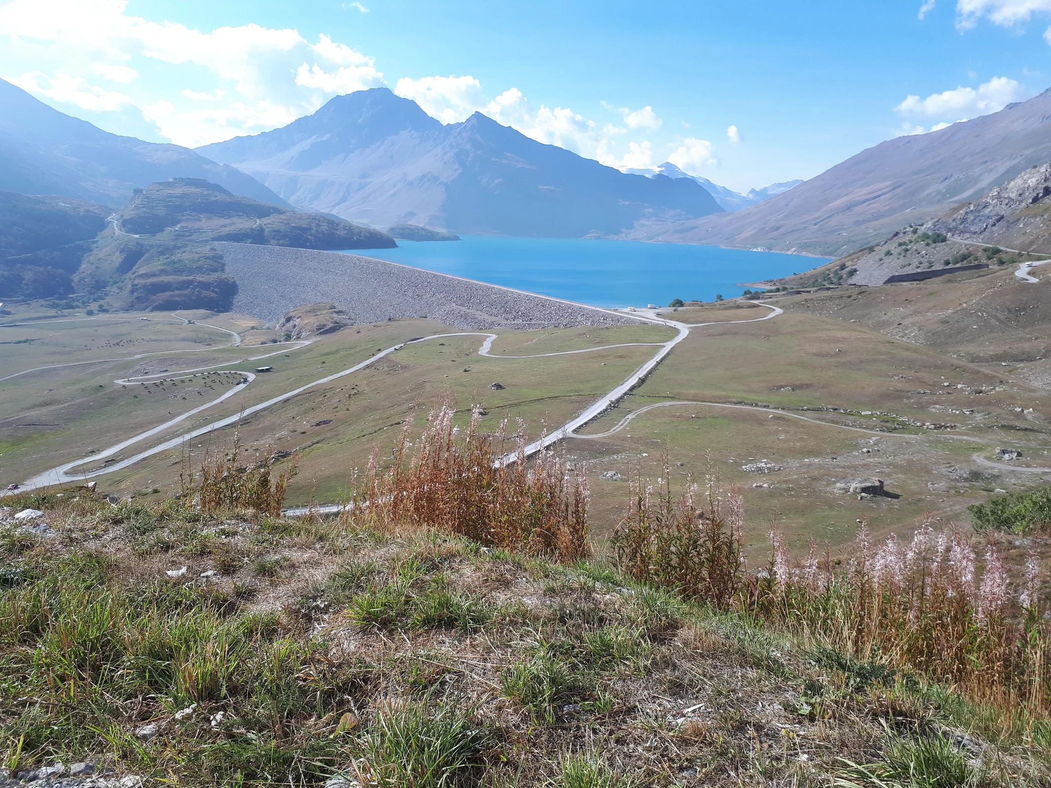 Die Mont-Cenis-Straße zieht sich in weiten Kurven oberhalb des türkisblauen Stausees