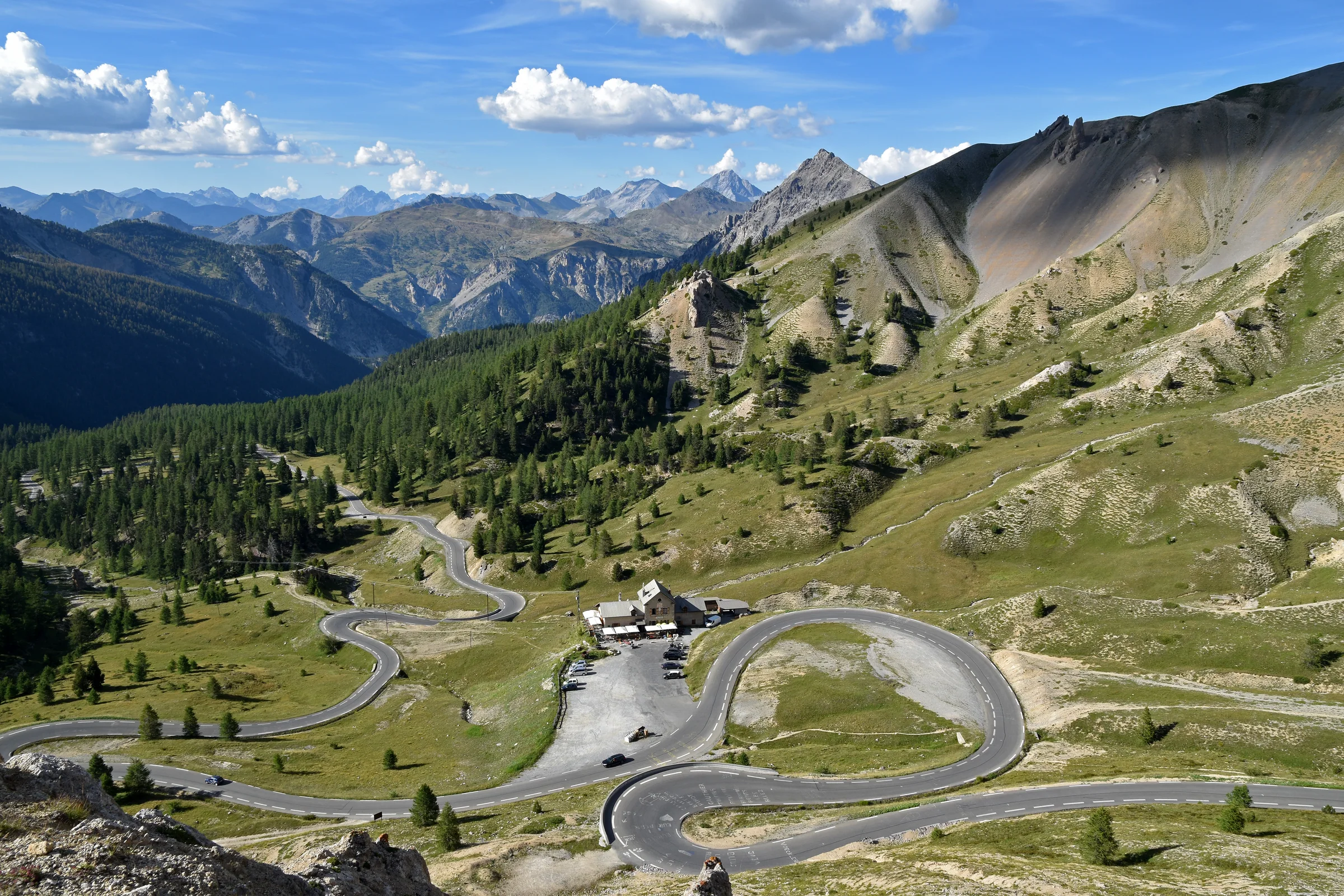 Enge Kehren der Izoard-Passstraße liegen zwischen hellen Schutthängen und dunklen Alpengipfeln