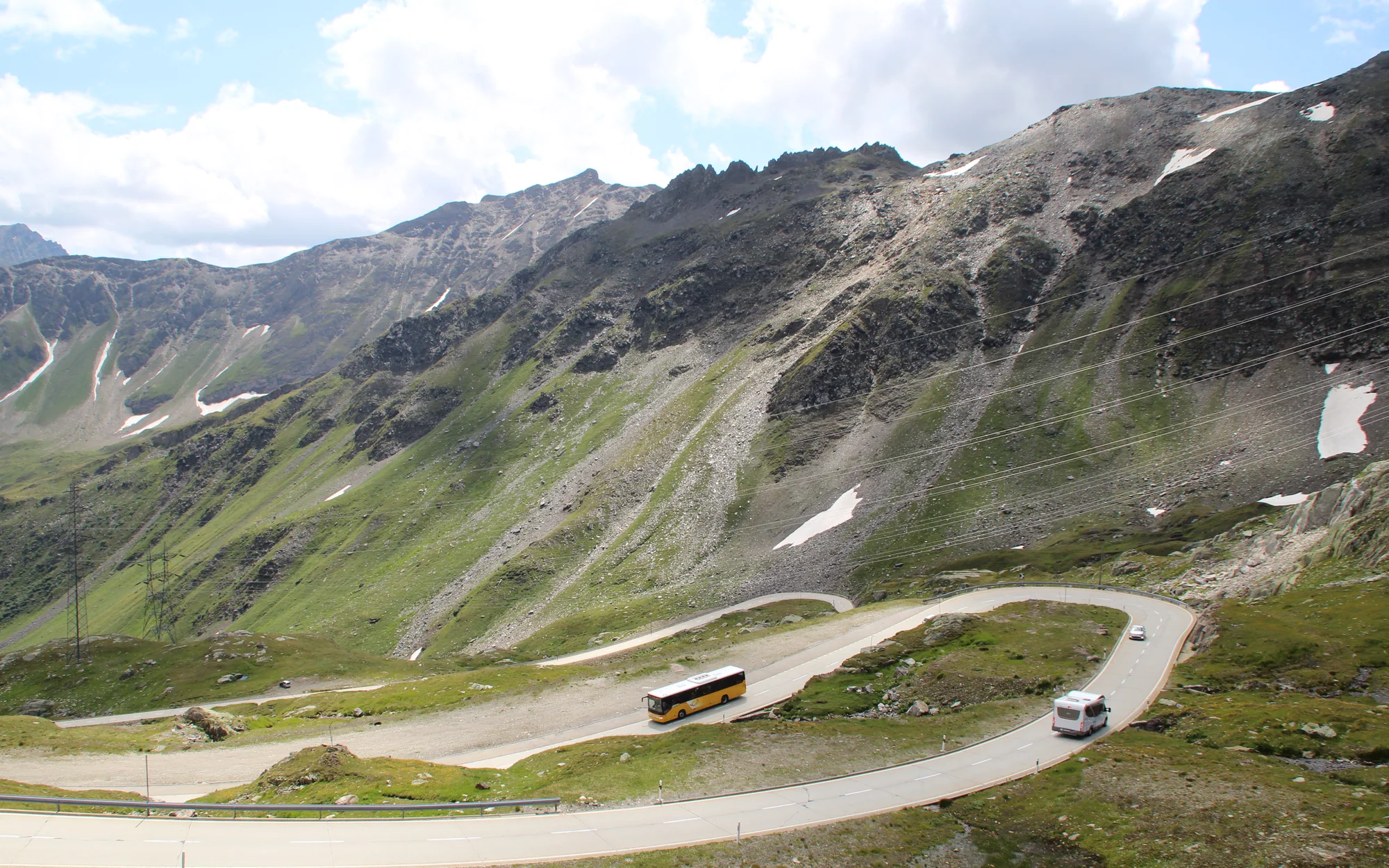 Weite Kehren der Nufenenpassstraße in der kargen Walliser Hochgebirgslandschaft