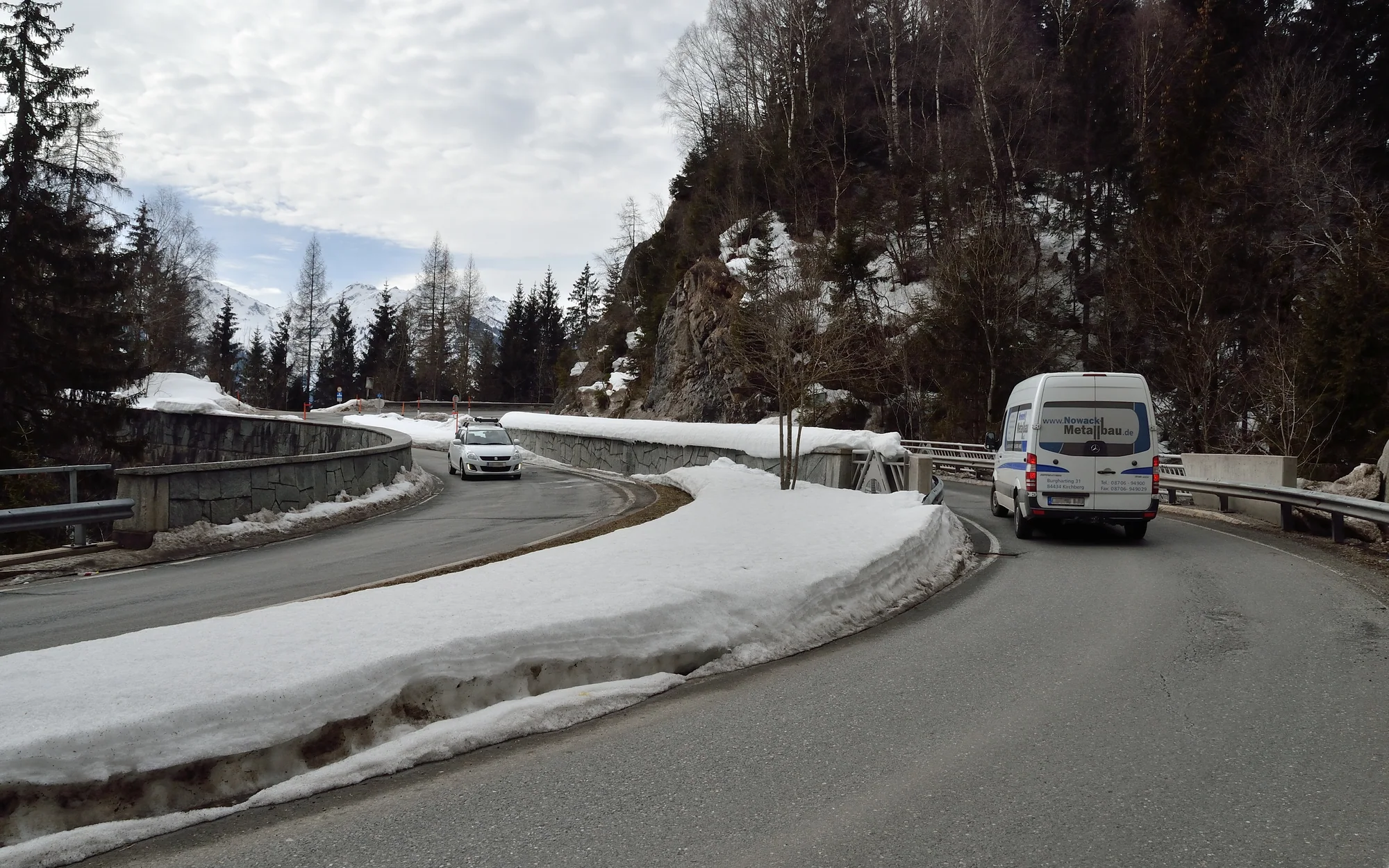 Kurvige Auffahrt zum Pass Thurn zwischen Waldhängen und winterlichen Straßenrändern