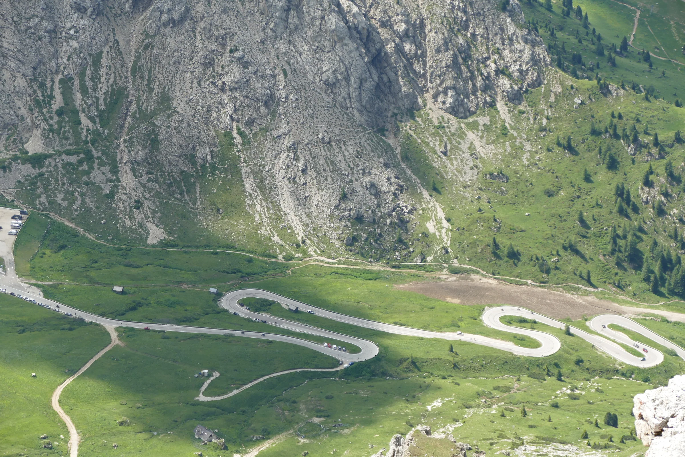 Die Serpentinen des Passo Pordoi ziehen sich durch die grüne Dolomitenflanke